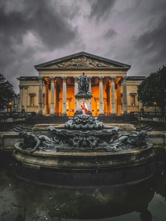 the fountain is lit up with orange lights