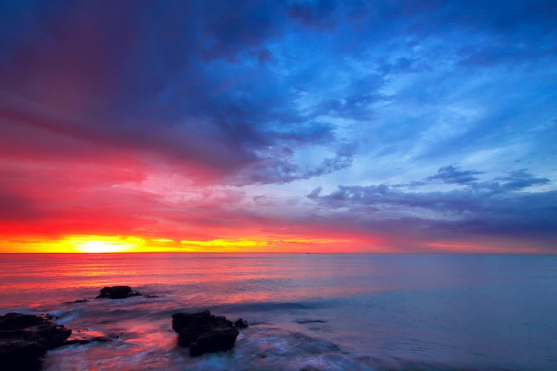 a lone boat is sitting on the shore in a beautiful sunset