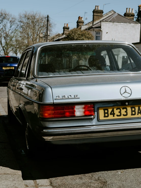 the rear of an old mercedes benz parked on a city street