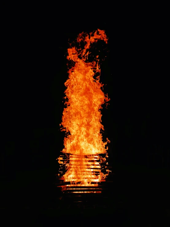 a close up of a burning fire with water and dark background