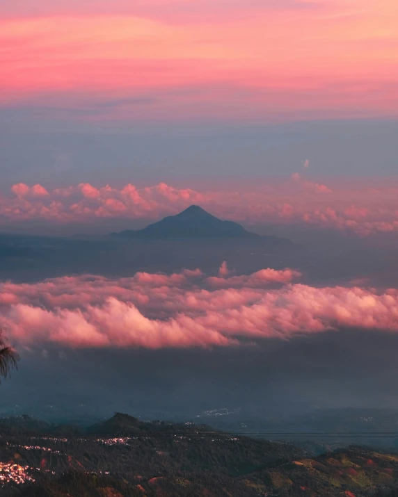 a pink sky with lots of clouds above it