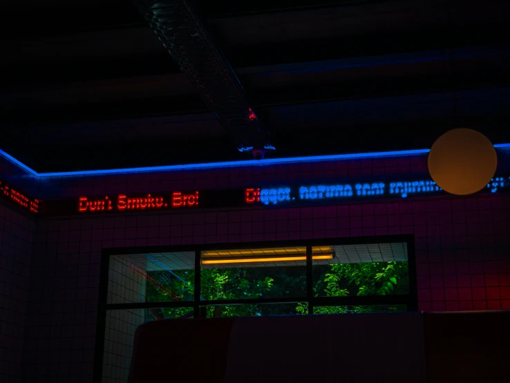 illuminated signs hang above the wall of a room