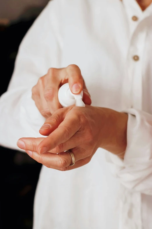 close up of someone holding a cream jar in their hand