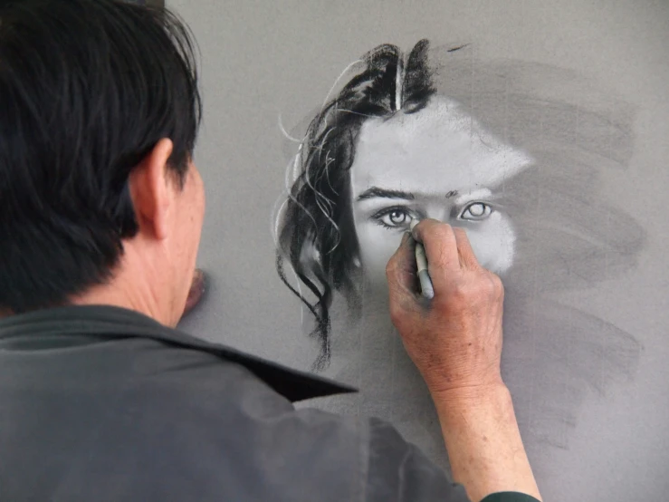 an artist is drawing soing with chalk on the wall