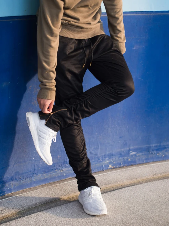 a man poses with his foot up against the wall