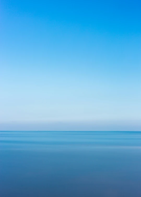 an empty beach with the blue sky in the background