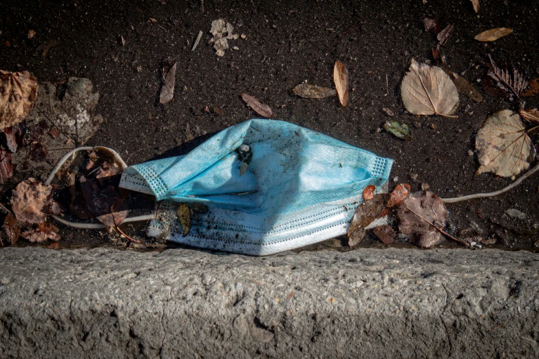 a blue mask sitting on top of an asphalt slab