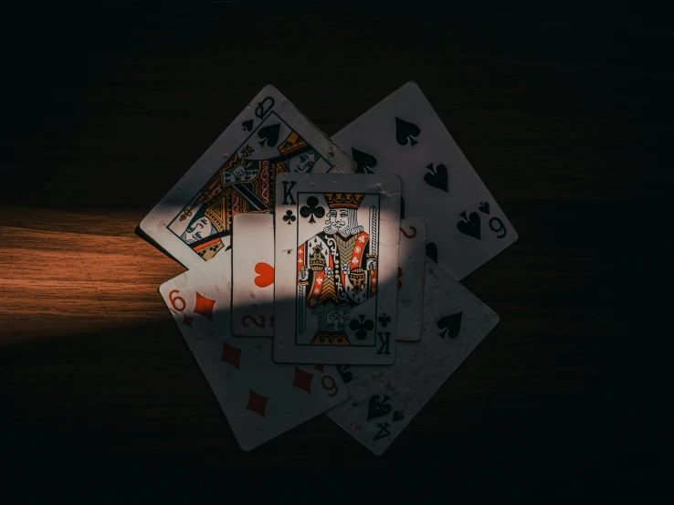 four playing cards sit on top of each other