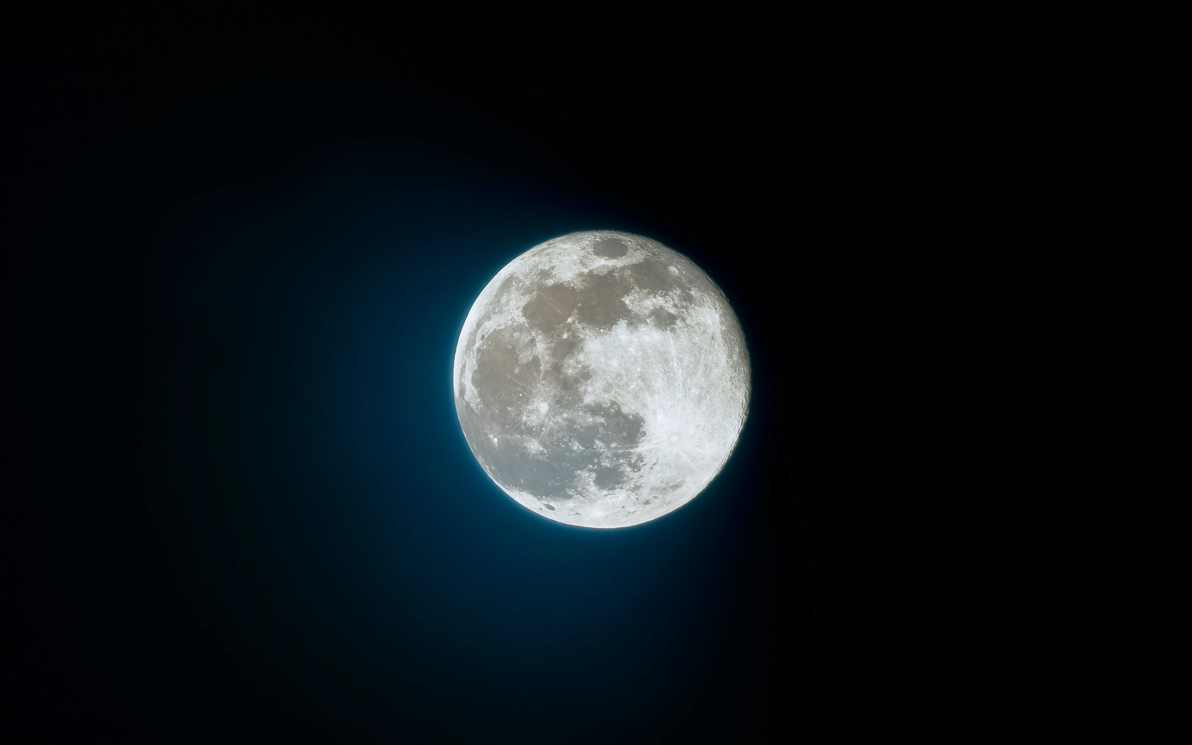 the moon shining brightly from a dark sky