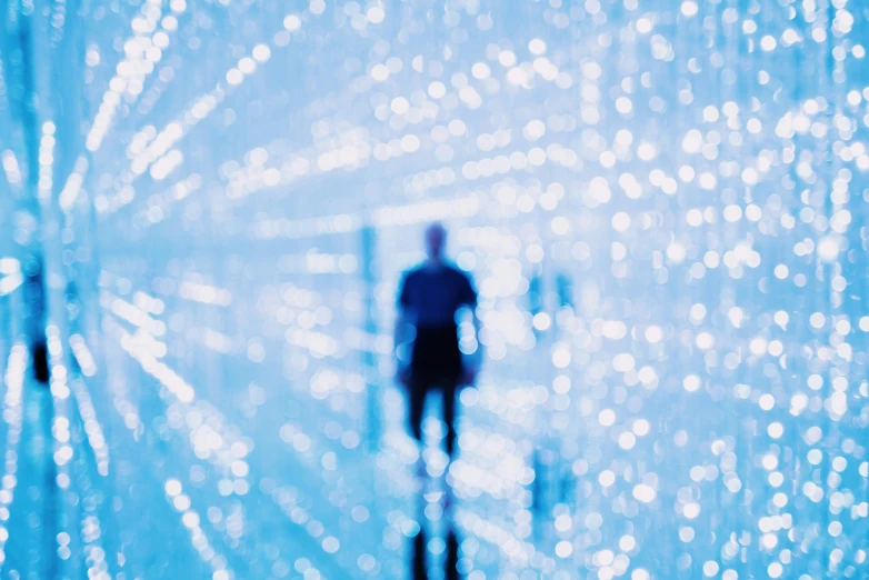 the man walks through the blue and white lights