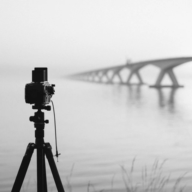 a large long bridge in the distance with a camera