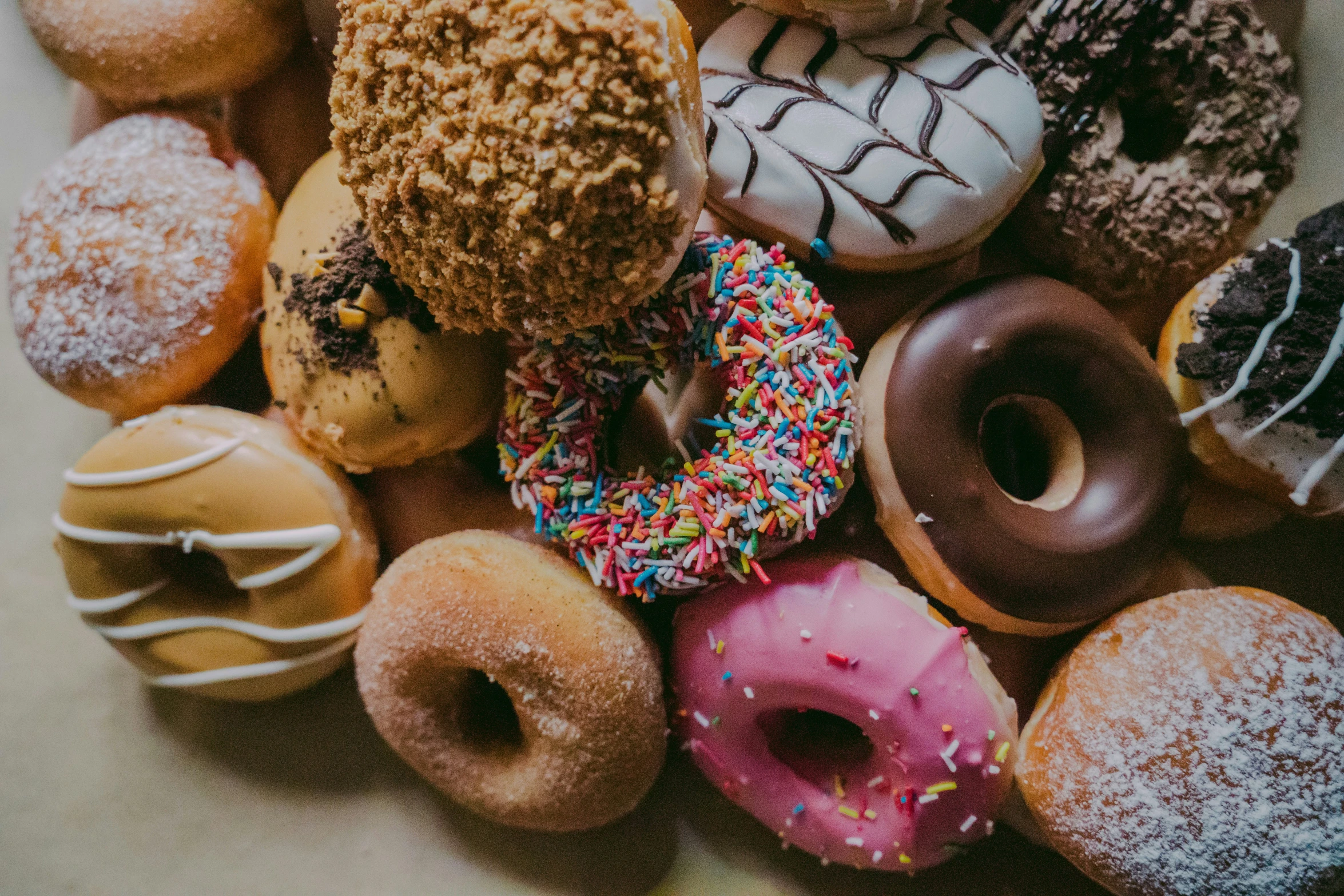 a bunch of different colored donuts stacked in a pile