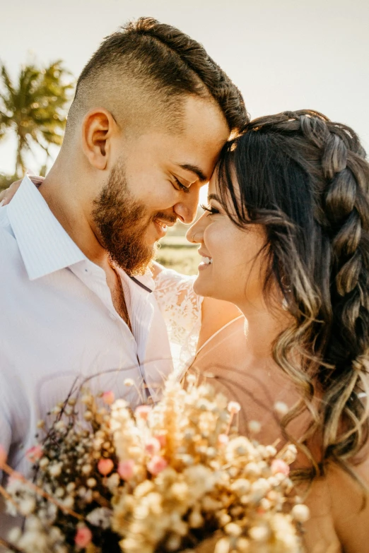 a bride and groom standing next to each other with palm trees in the background