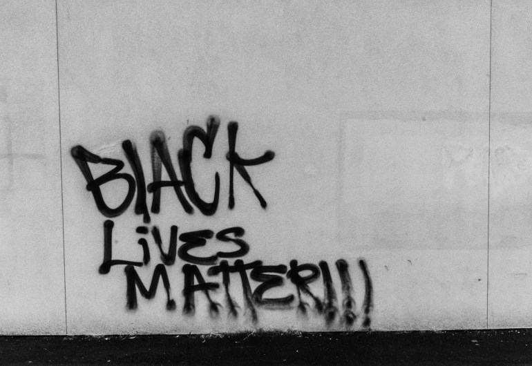 some black graffiti written on the side of a wall
