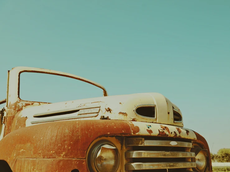 the rusted old truck is driving along the dirt
