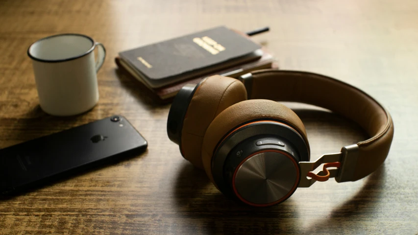 headphones are resting on a table next to a book
