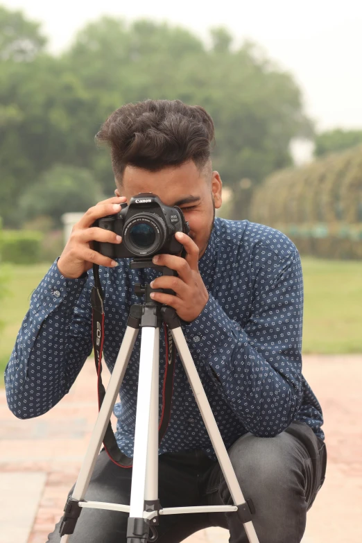 a man sitting down taking a po with his camera