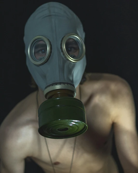 the man wearing a gas mask and some chain necklace