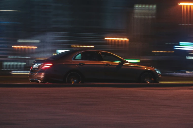 a car driving down the street at night with motion blurs