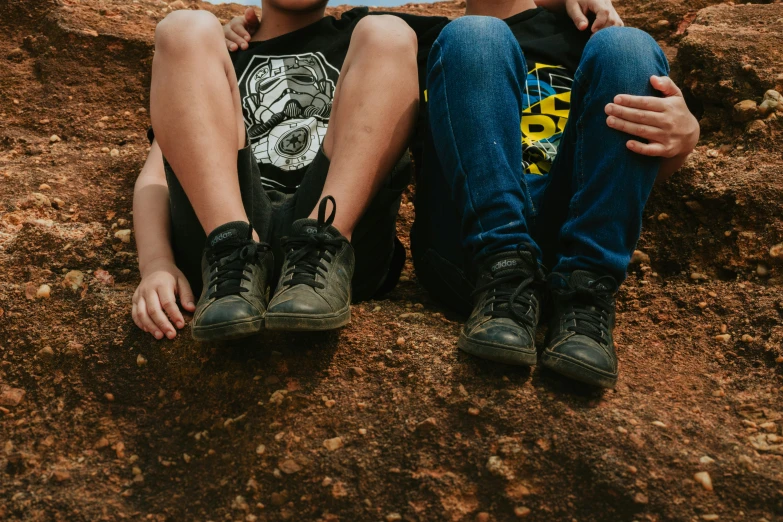 two s sitting on a dirt hill