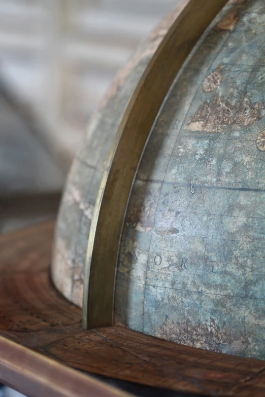 a wooden stand with a metal globe on top