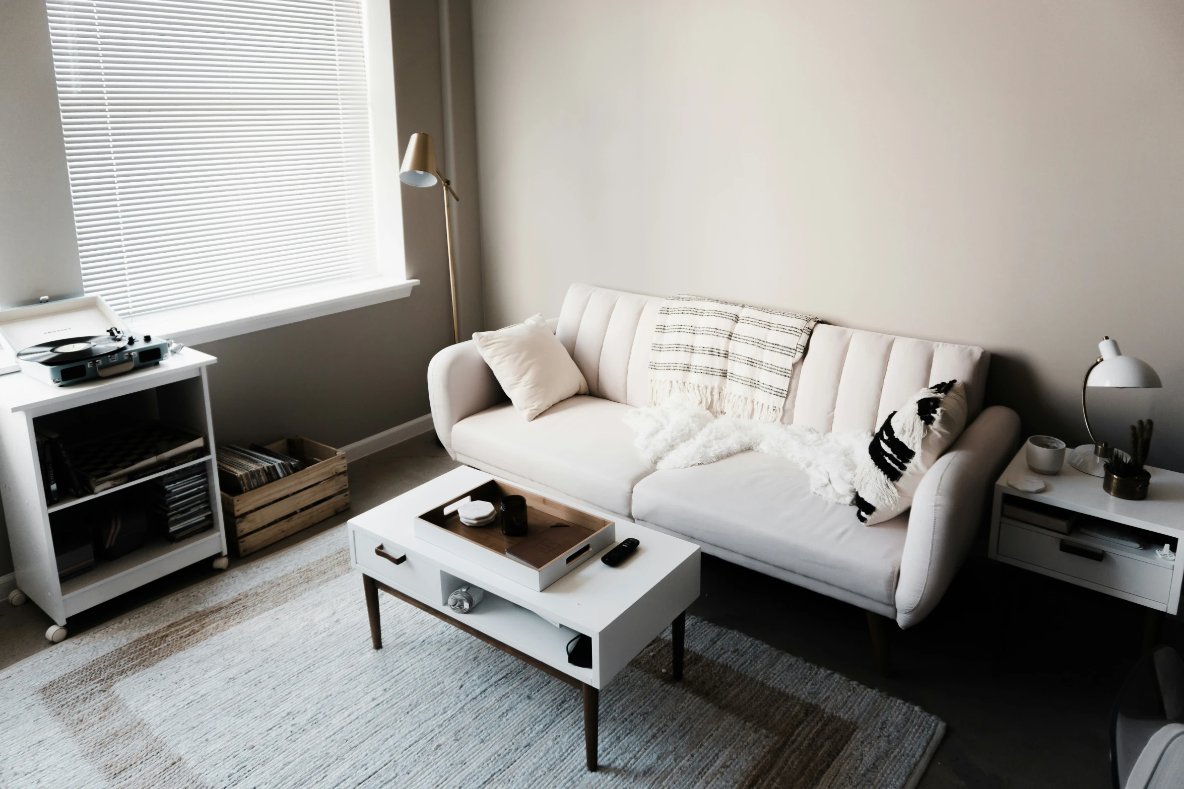a very clean looking living room with white furniture