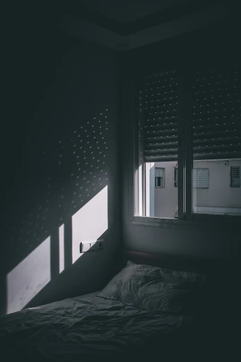 dark bedroom with sun shining through the window and the shadows are cast