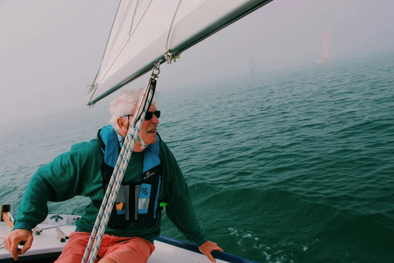 a man sitting on the bow of a sail boat