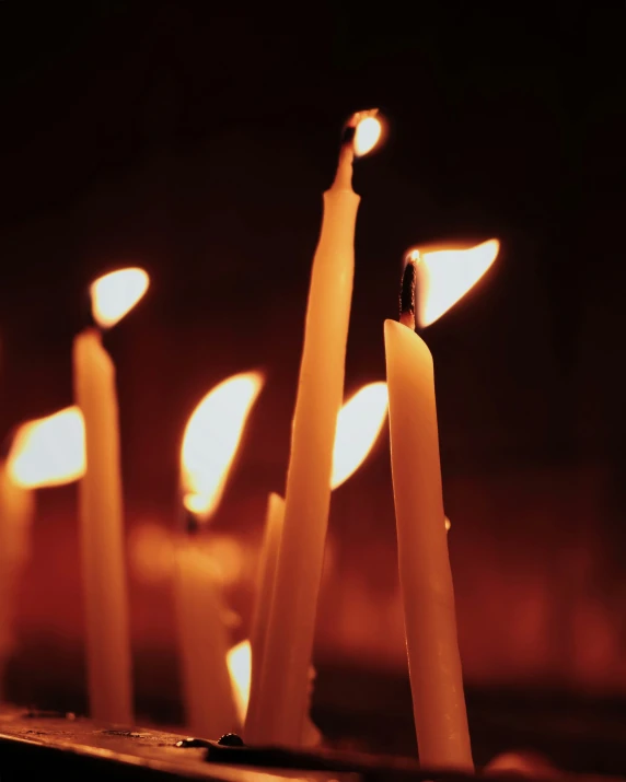 candles of white lit up against a dark background