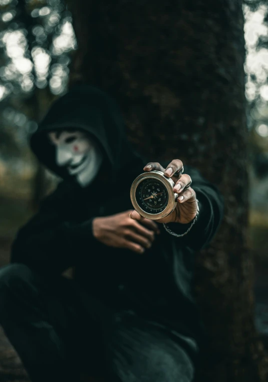 an evil man in a creepy mask with a stopwatch is holding out his hand to the camera