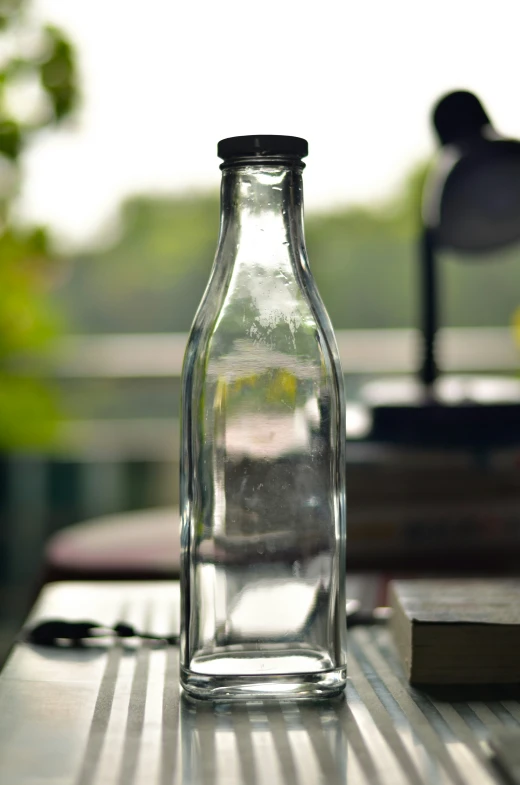 an empty glass bottle sitting on a table