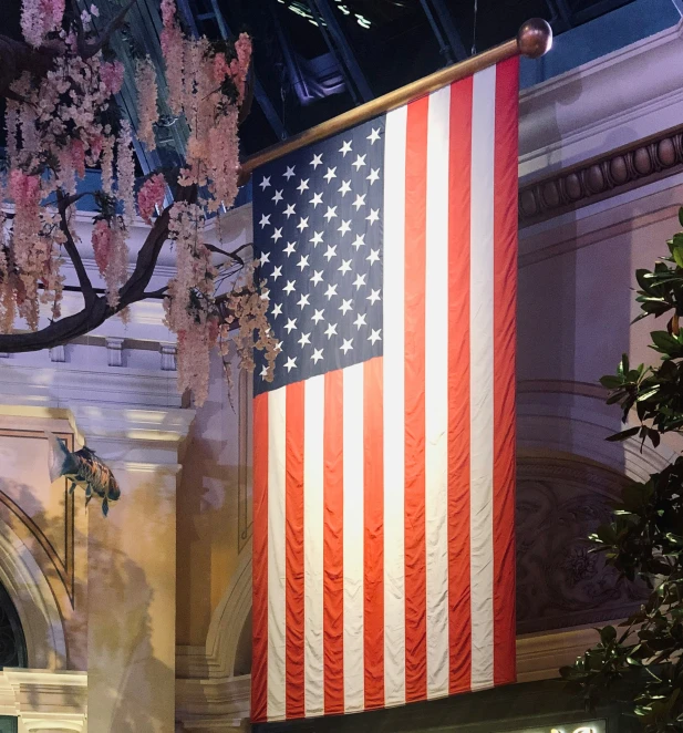 an american flag is hanging from the side of a wall