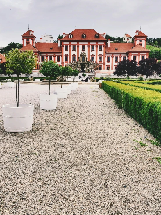 a large white vase filled with water in front of a red building