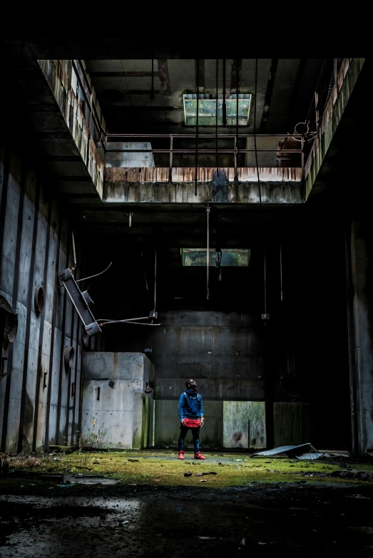 the man stands under a tall stairway in a building