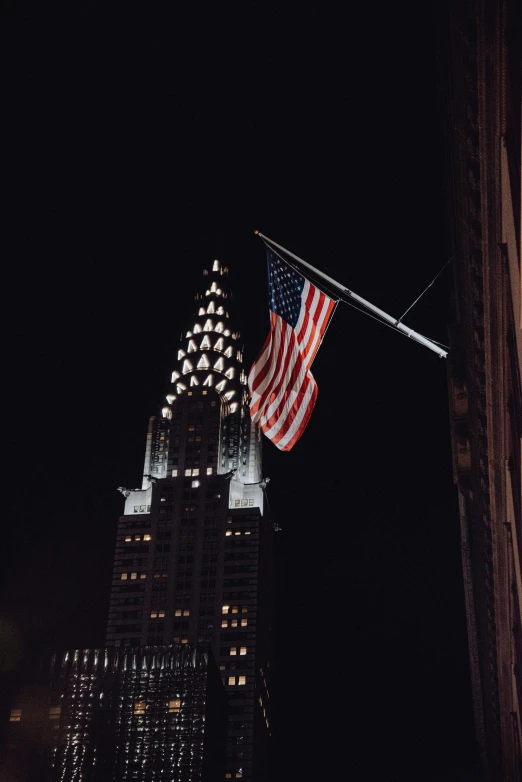 an american flag is hanging on the top of a building