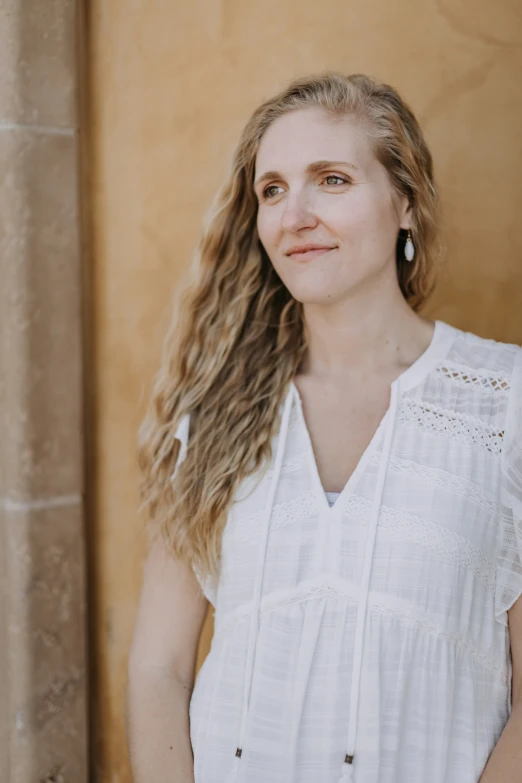 a woman poses for a po against a wall