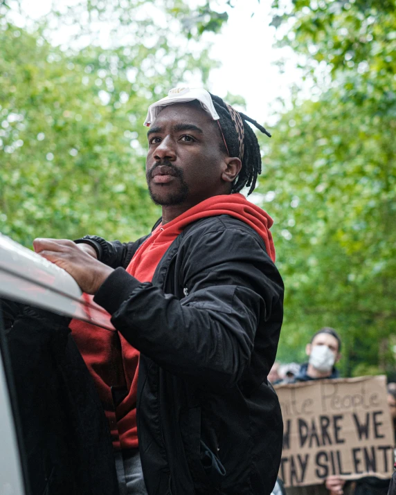 a man holding onto his black shirt outside