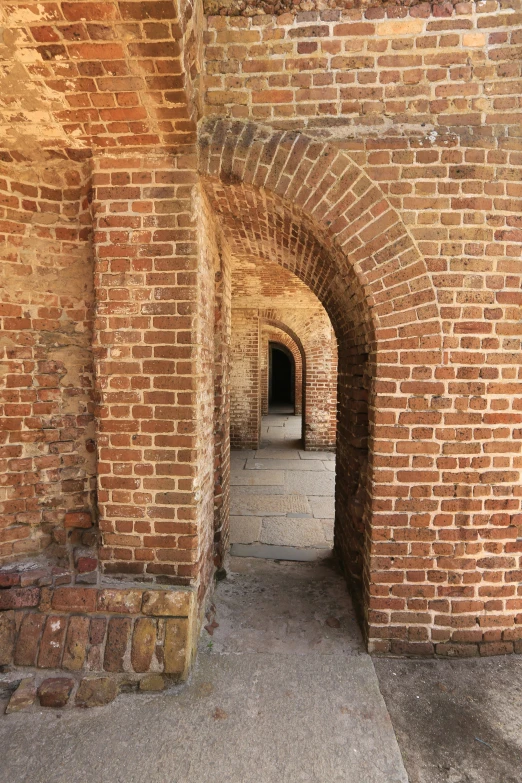 an arched hallway in a stone wall with bricks