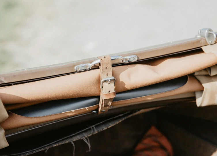 a brown briefcase with a leather strap hanging on the handle