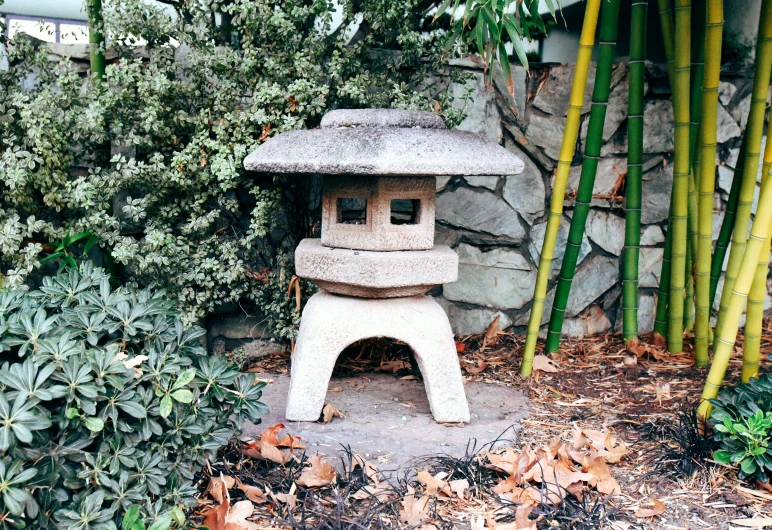 a stone lantern near some plants and flowers