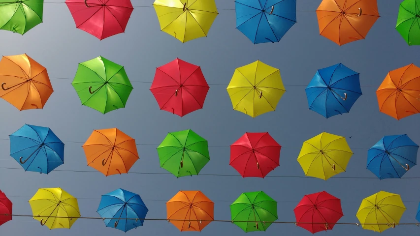 a bunch of brightly colored umbrellas on a wire