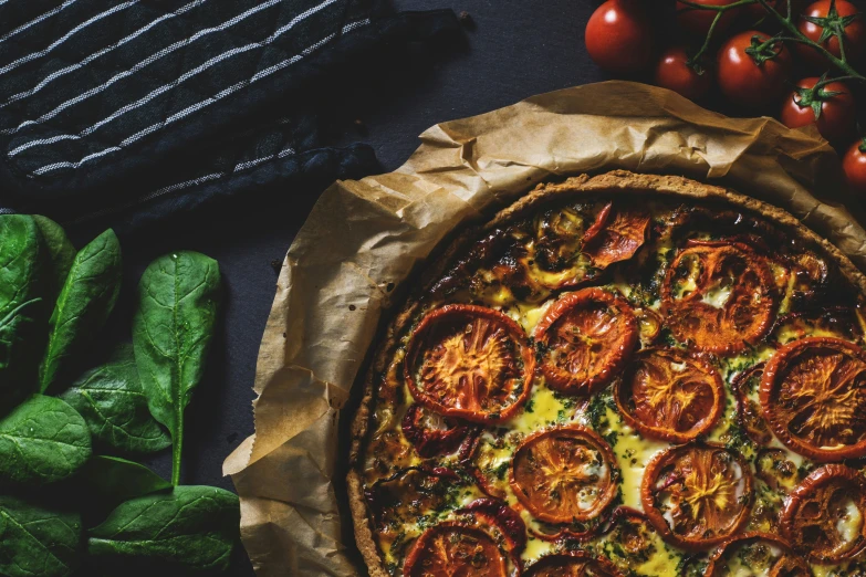 a small pizza and some tomatoes on the table