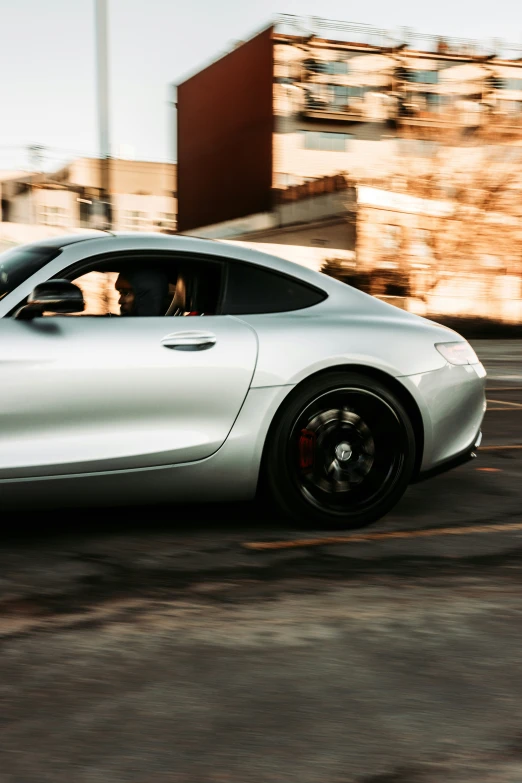 a silver sports car parked in front of a building