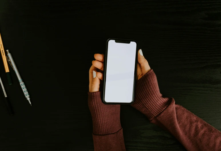 a person holds an iphone up in their hand