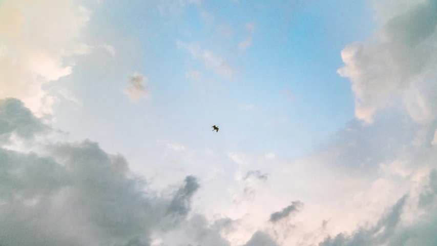 the silhouette of an airplane in a partly cloudy sky