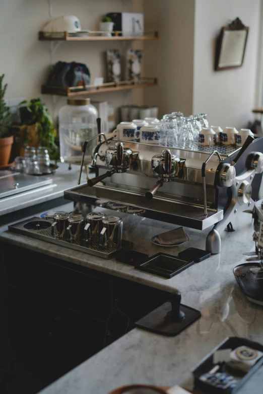 a metallic kitchen range with many cups and pots on the stove