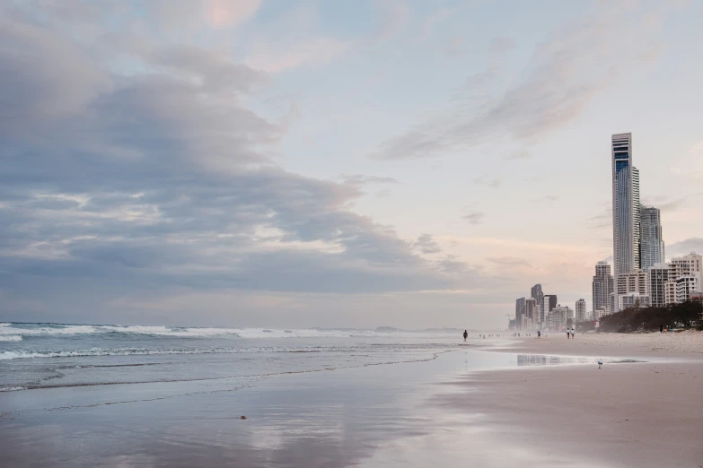 a large building is in the distance on a beach