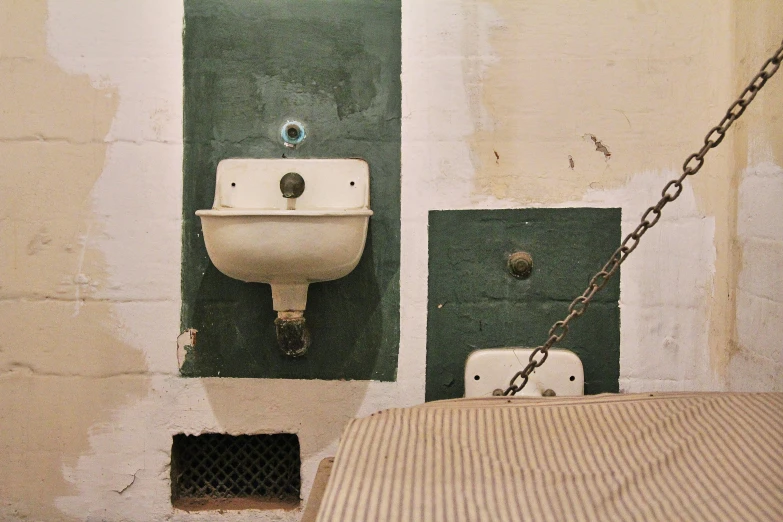 the bathroom is dirty with green paint and old toilet