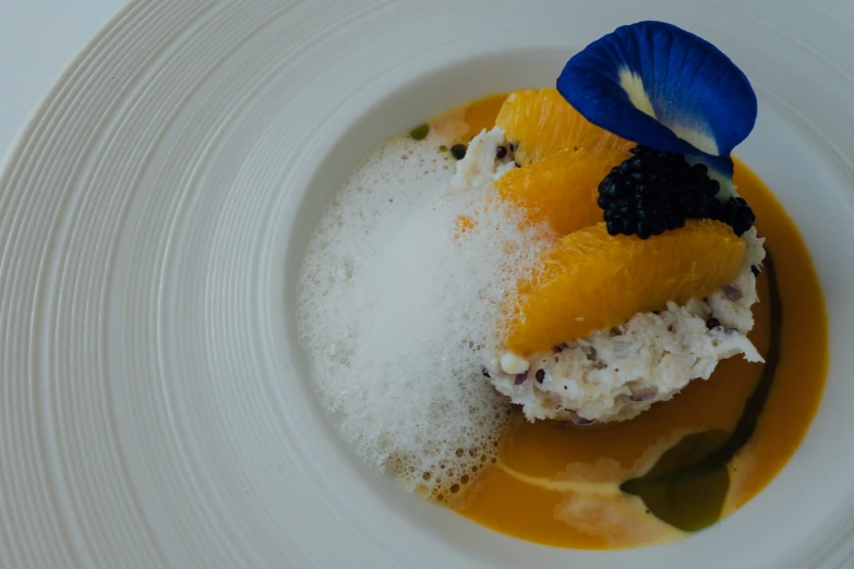 a white plate with a blue flower and sauce