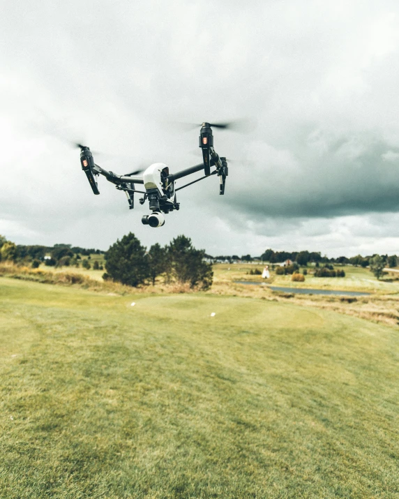 a flying black quad camera high up in the air